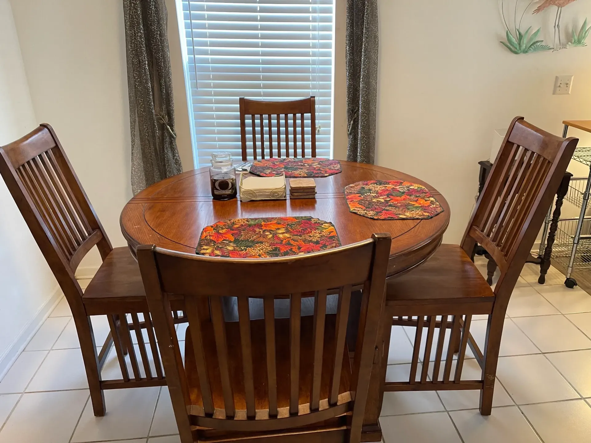 A dining room table with four chairs in front of a window.