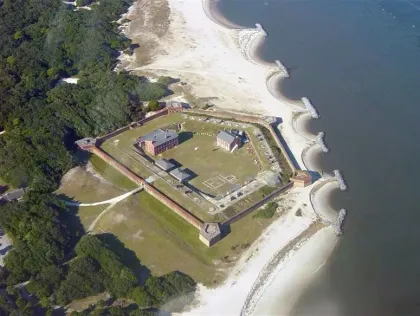 An aerial view of a castle on the shore of a body of water