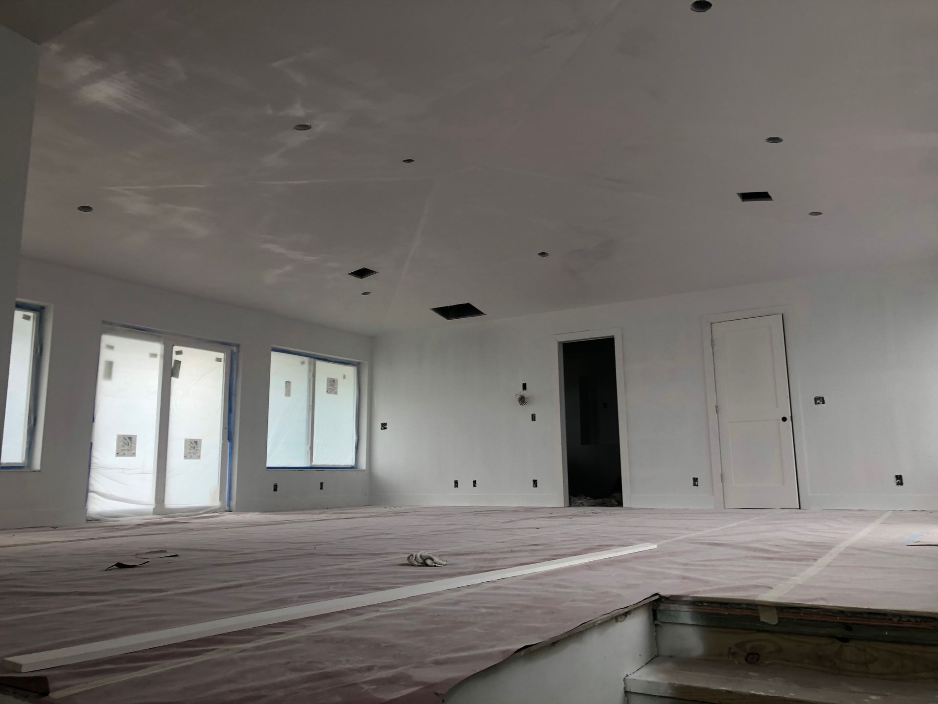 A large empty room with white walls and a wooden floor.