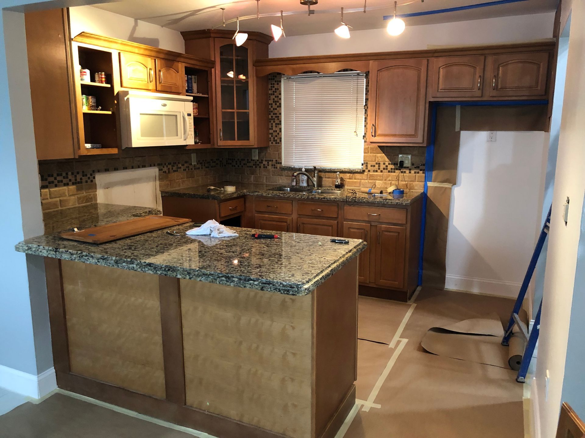 A kitchen with wooden cabinets and granite counter tops