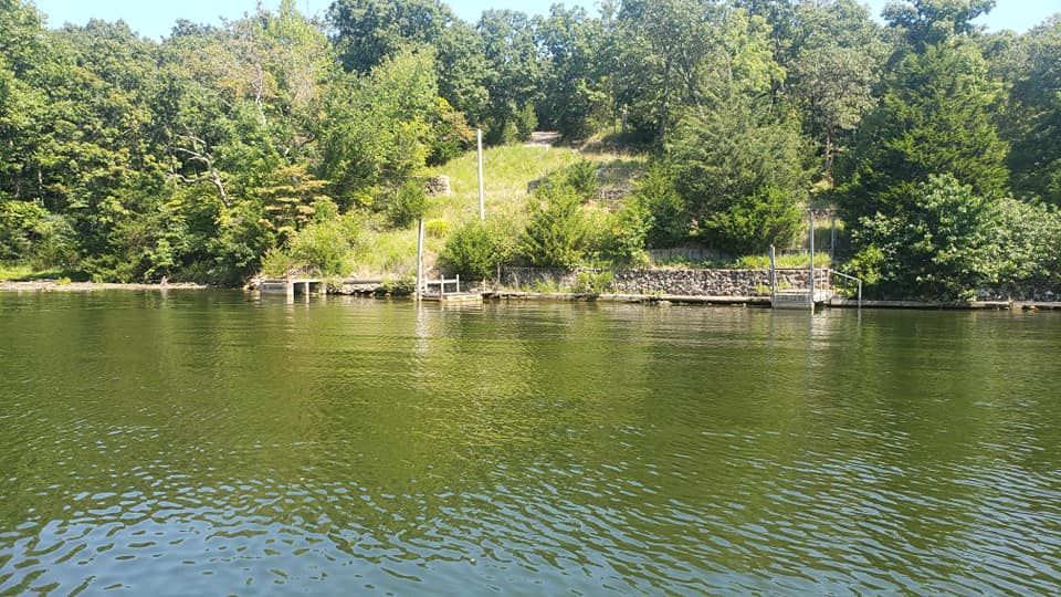 A dining room with a table and chairs and a wooden staircase.