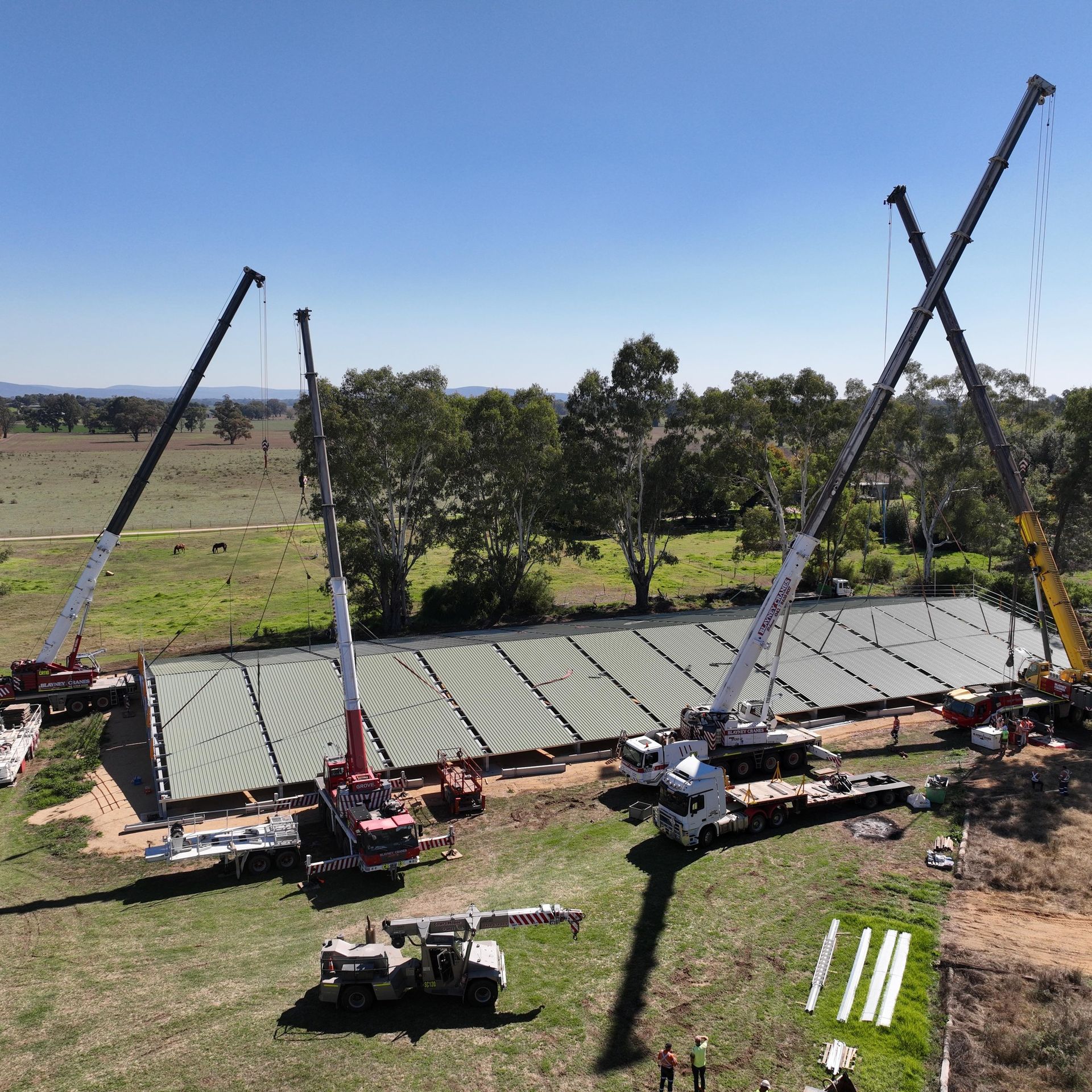 An aerial view of a construction site with trucks and cranes