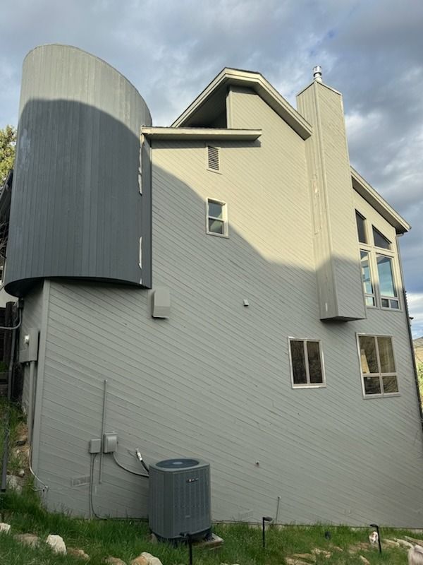 A large house with a lot of windows and a large air conditioner on the side of it.