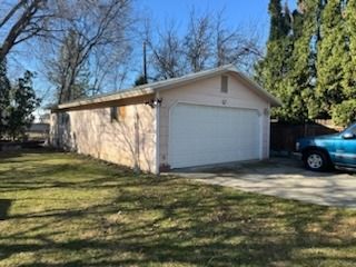 A blue truck is parked in front of a garage.