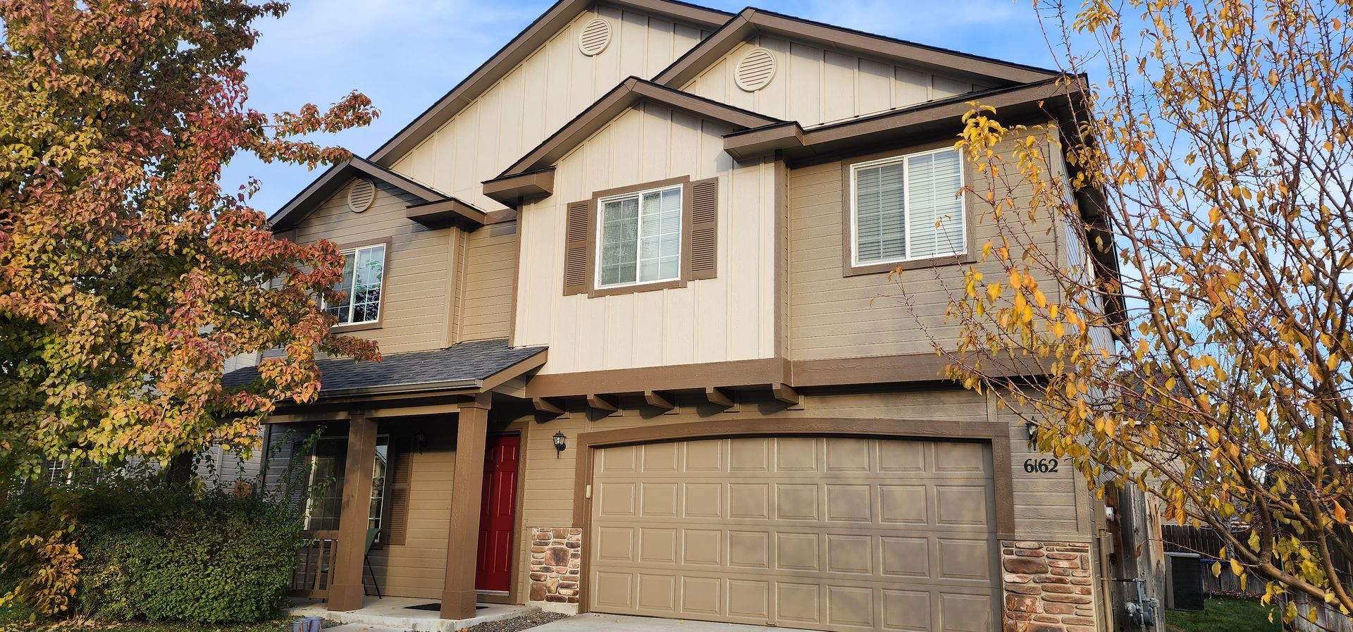 A large house with a basketball hoop in front of it.