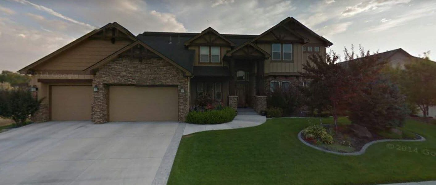 A large house with a basketball hoop in front of it.