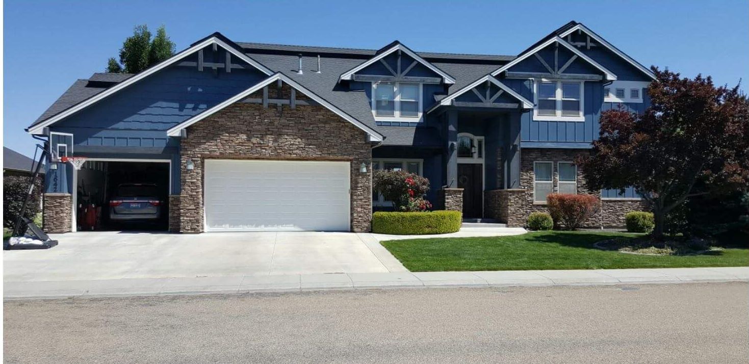 A large house with a basketball hoop in front of it.