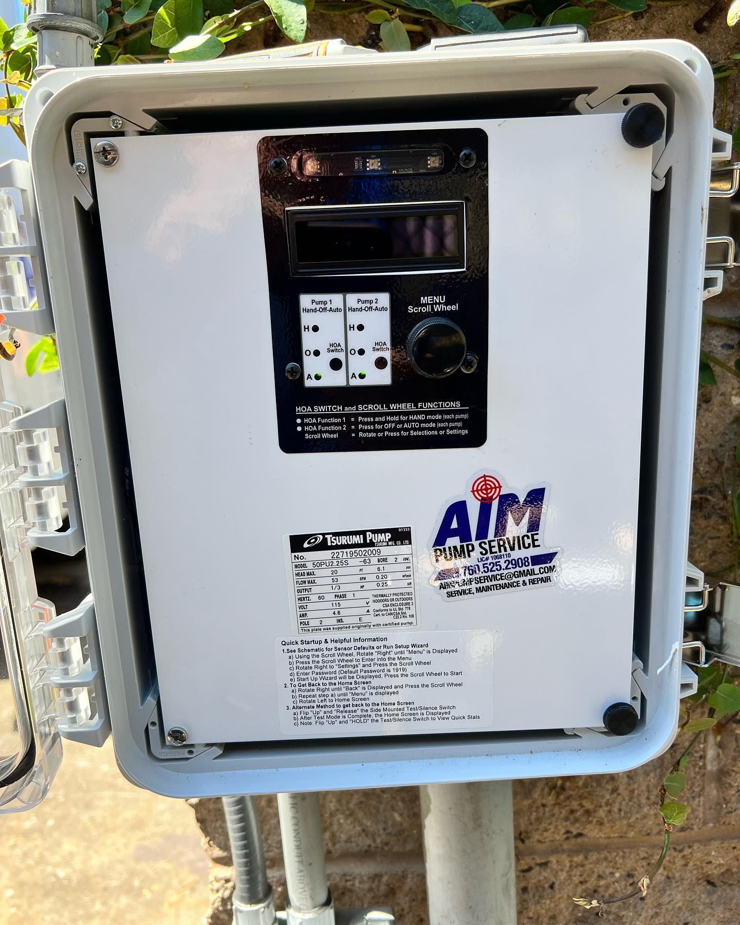 An AIM Pump Control box with a digital display and control knob inside a white protective enclosure on a pole.