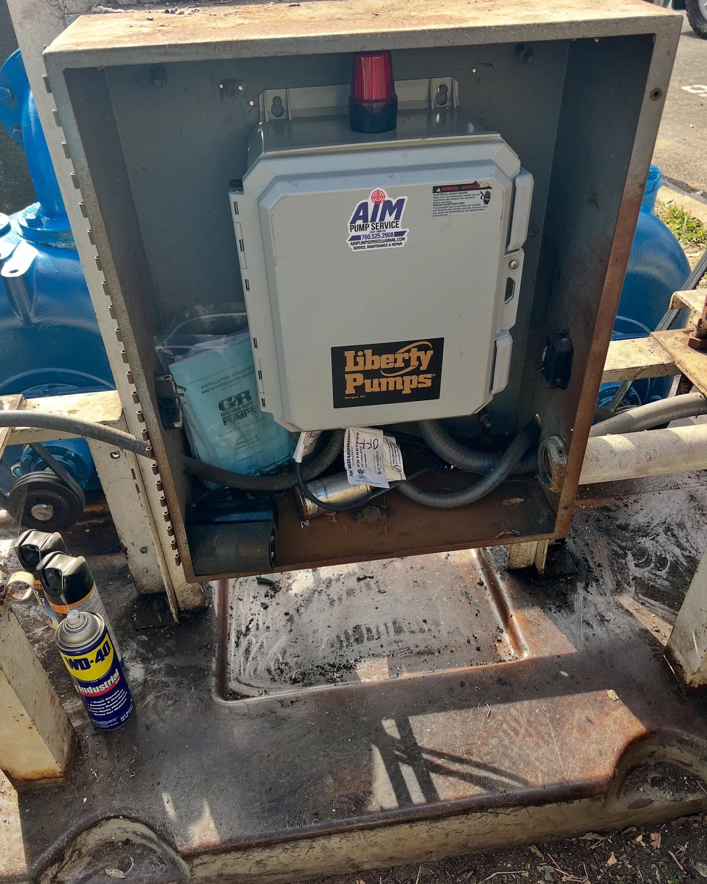 A Liberty Pumps control panel box with a red beacon light mounted in a metal outdoor industrial enclosure.