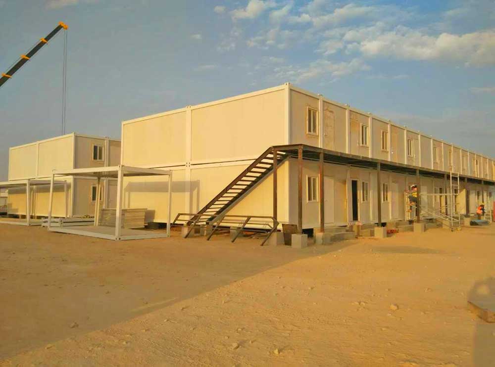 A large building with stairs leading up to it is being built in the desert.