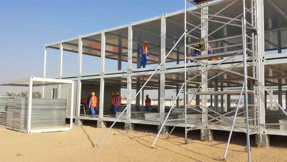 A group of construction workers are working on a large building.