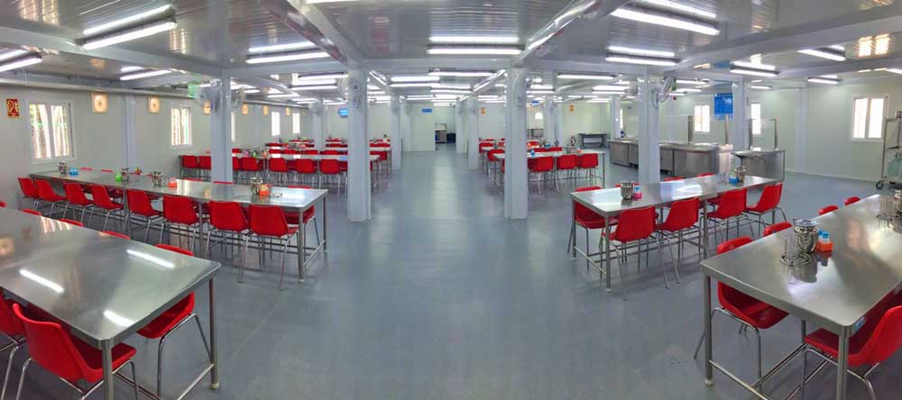 There are many tables and chairs in this large room.