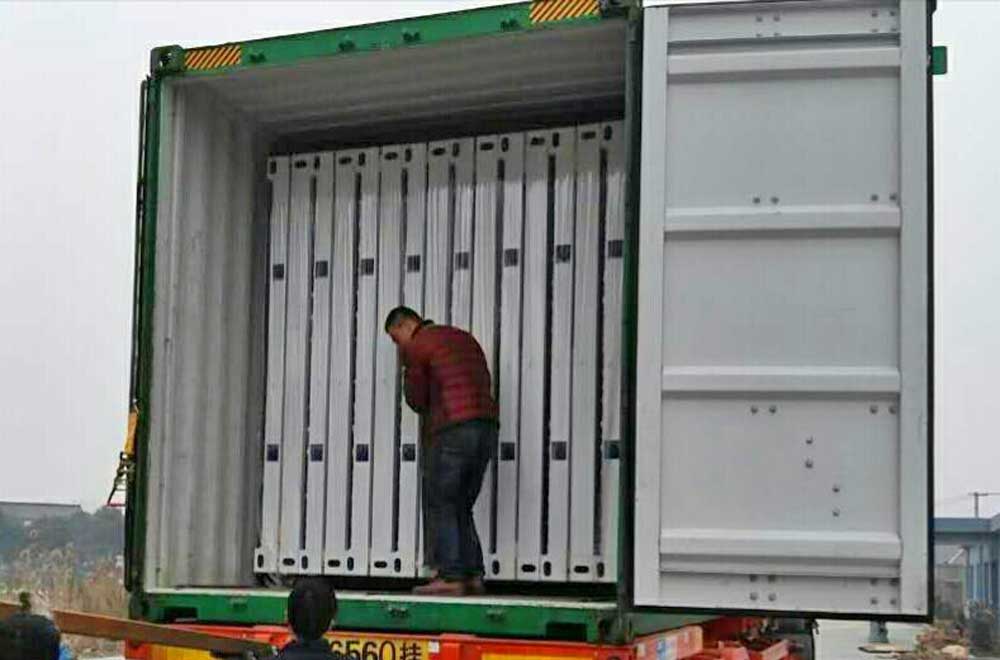 A man is standing inside of a shipping container.
