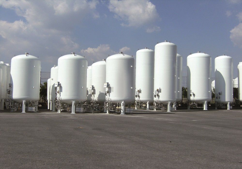 A row of white tanks are lined up in a parking lot