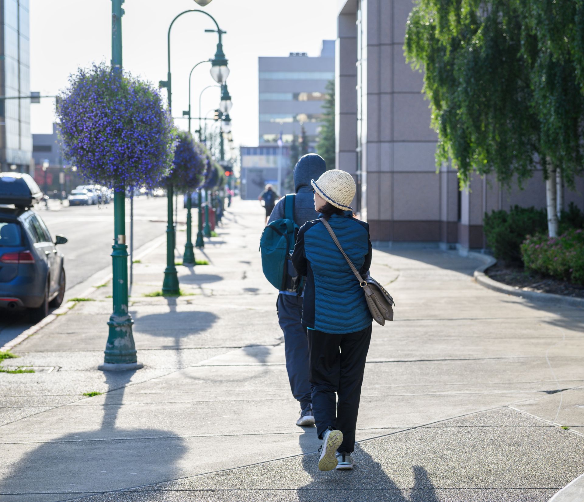 A man and a woman are walking down a sidewalk