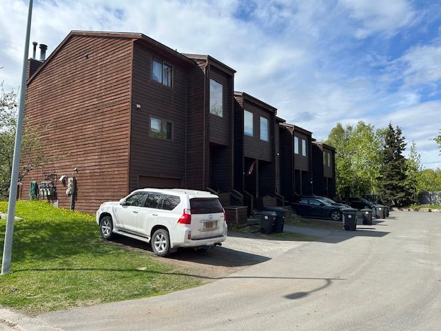 A purple truck is parked in front of a row of apartment buildings.