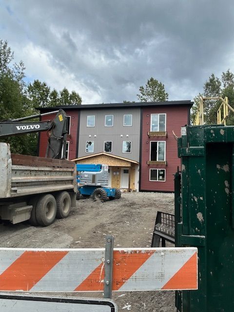 A large apartment building with cars parked in front of it.
