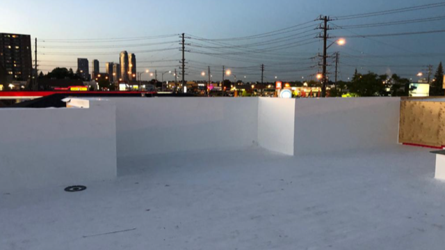 A white roof with a city skyline in the background.