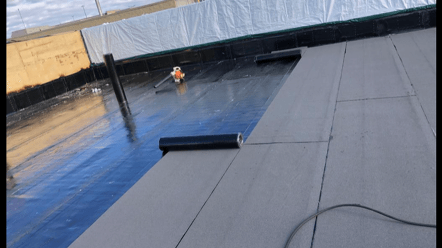A person is working on a roof with a vacuum cleaner.
