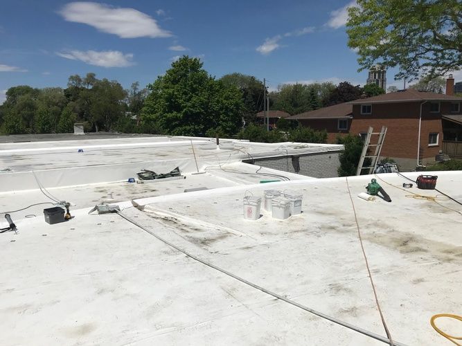 A white roof with a ladder and tools on it.