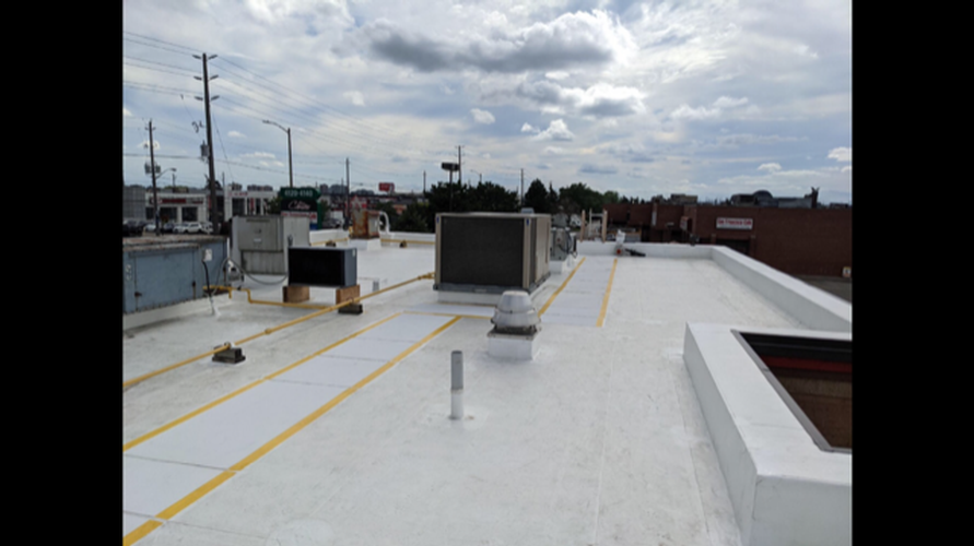 The roof of a building with a white roof and yellow lines on it.