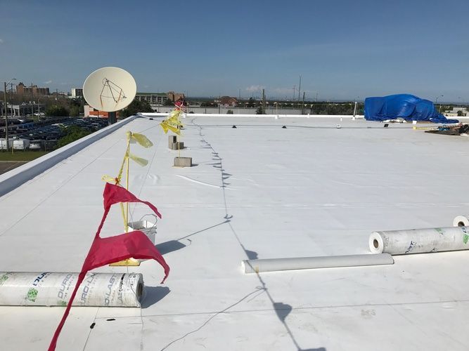 A satellite dish is sitting on top of a white roof.