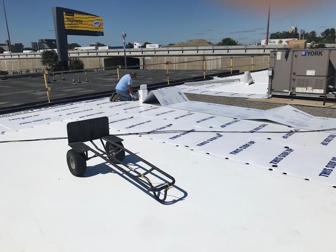 A man is working on the roof of a building.