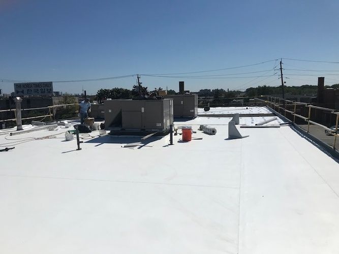 The roof of a building with a white roof and a blue sky in the background.
