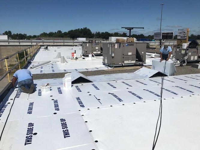 A man is working on the roof of a building