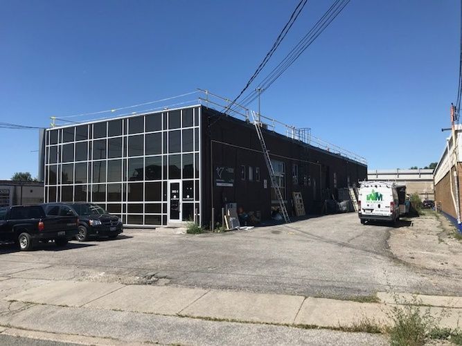 A large building with a lot of windows and cars parked in front of it.