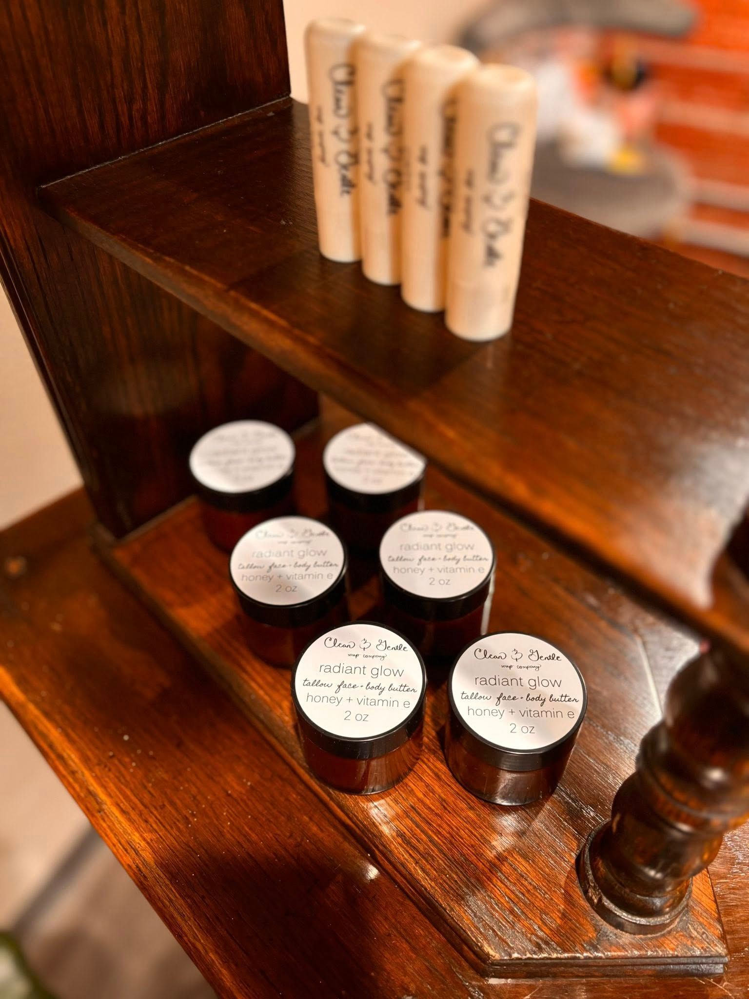 Shelves holding jars of cream and lip balm tubes, brown wood, white labels with text.