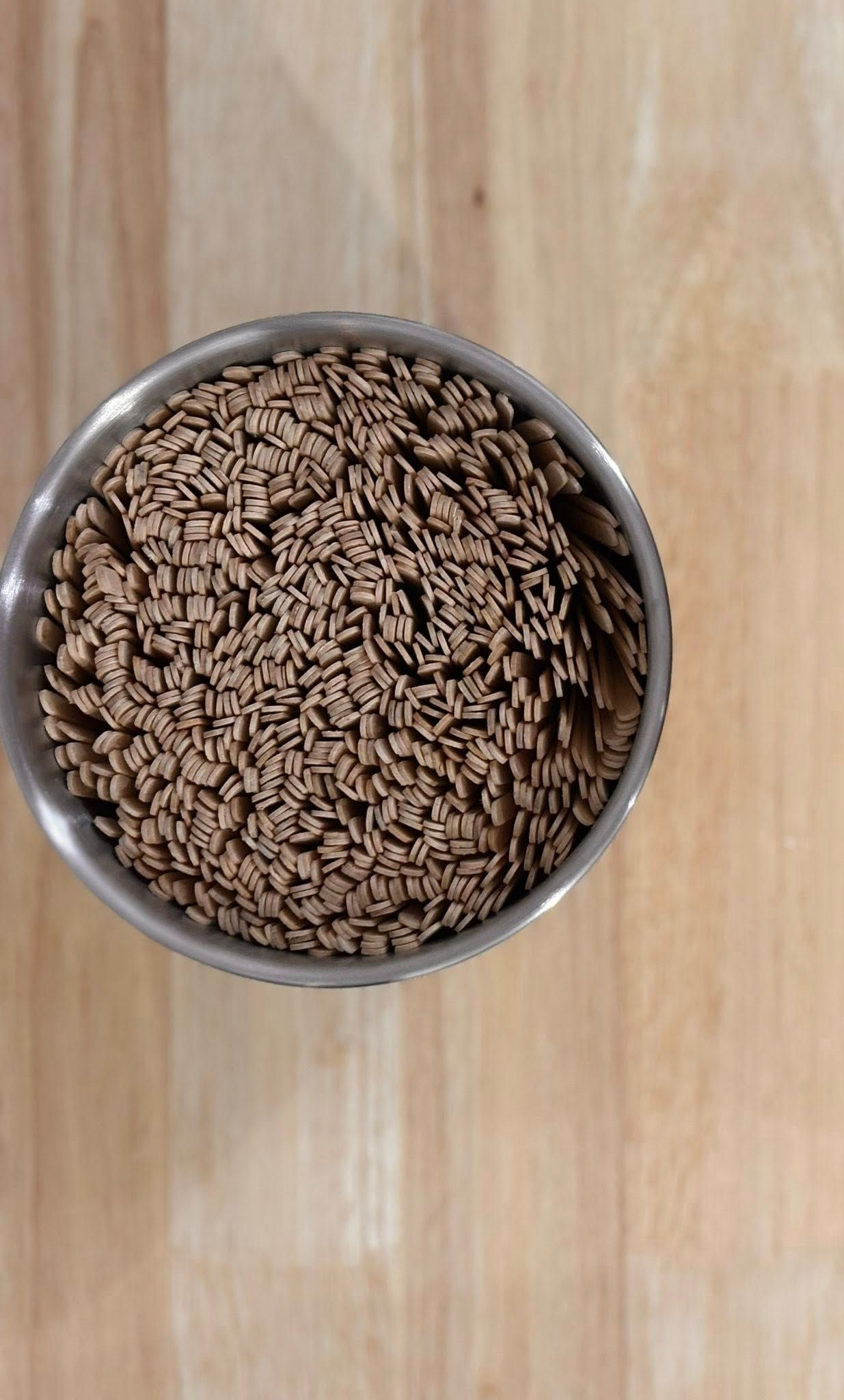 Bowl of brown cereal on a wooden surface.