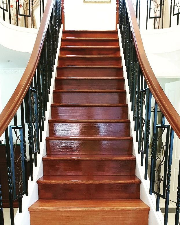 A wooden staircase with a black railing in a house