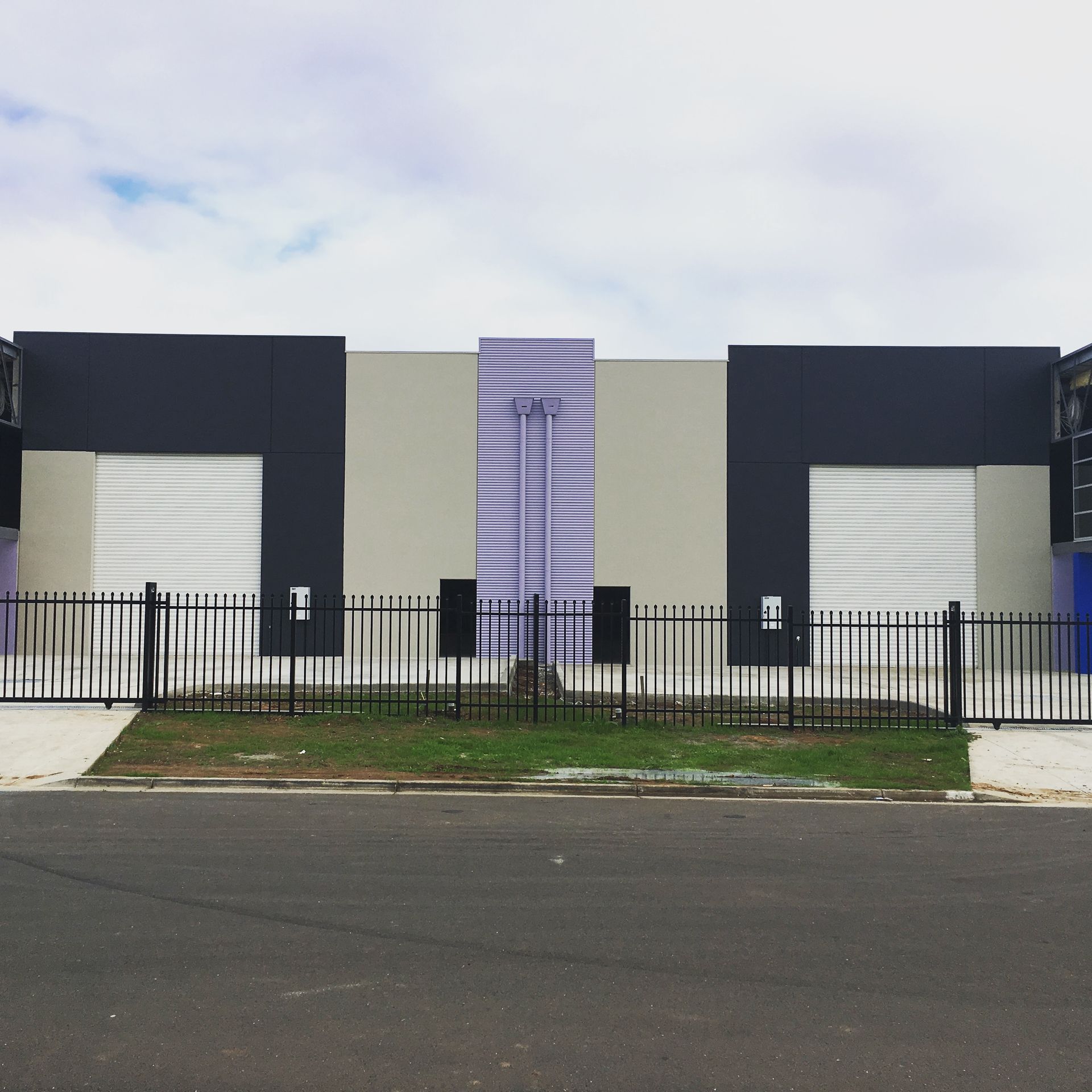 A black and white building with a fence around it