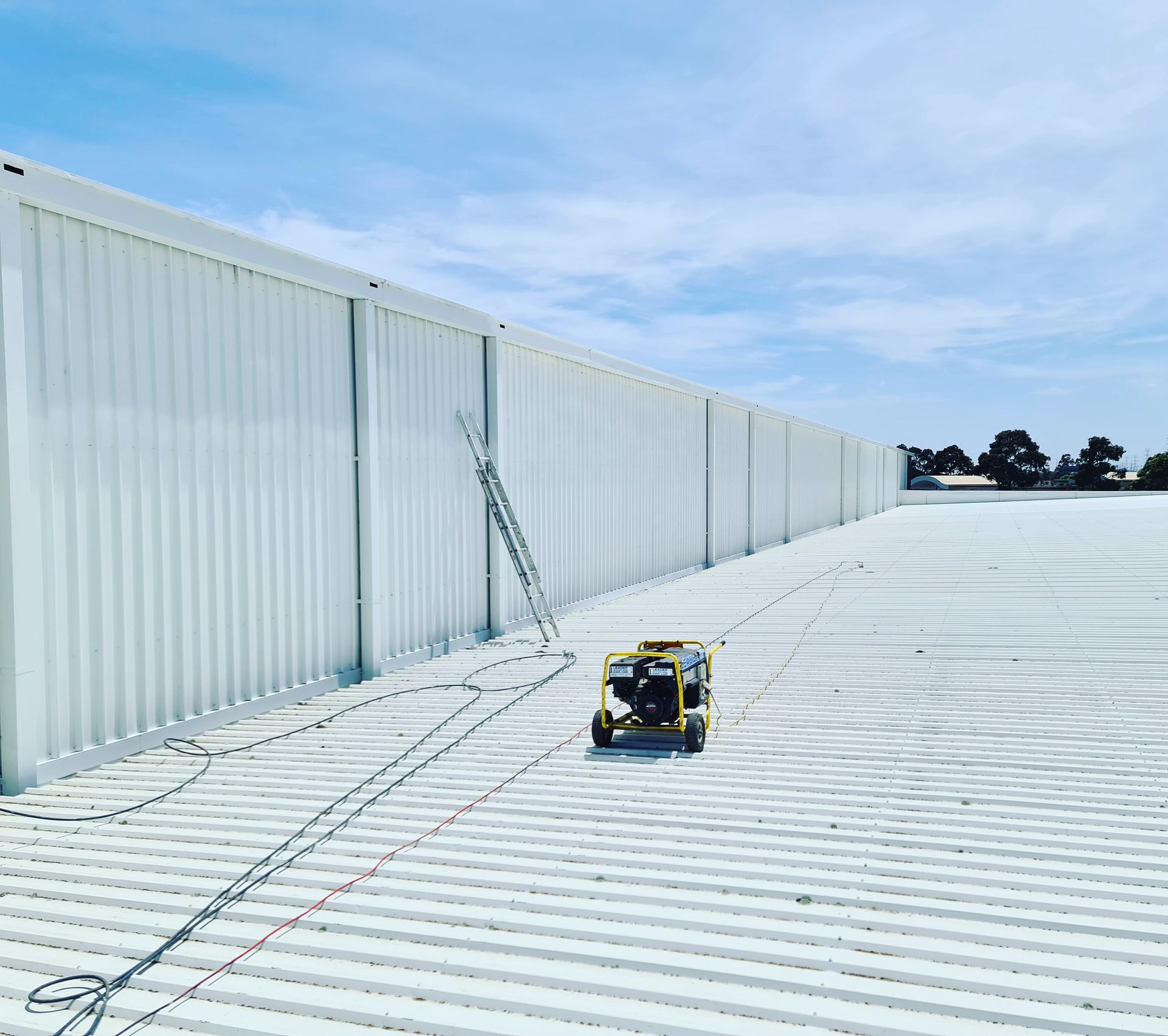A yellow generator is sitting on the roof of a building.