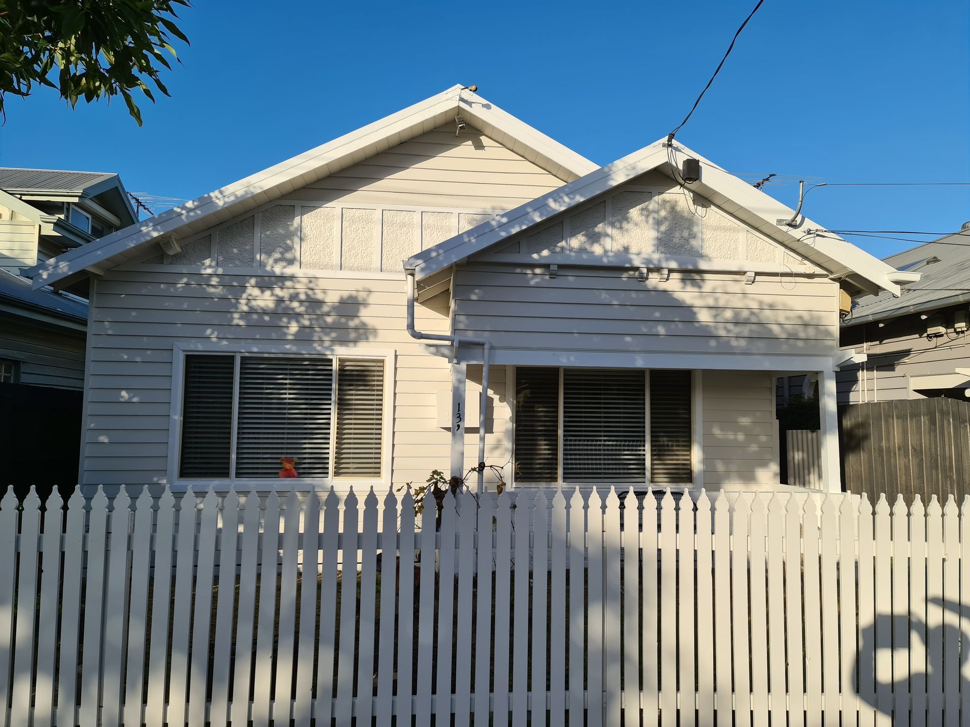 A white house with a white picket fence in front of it.