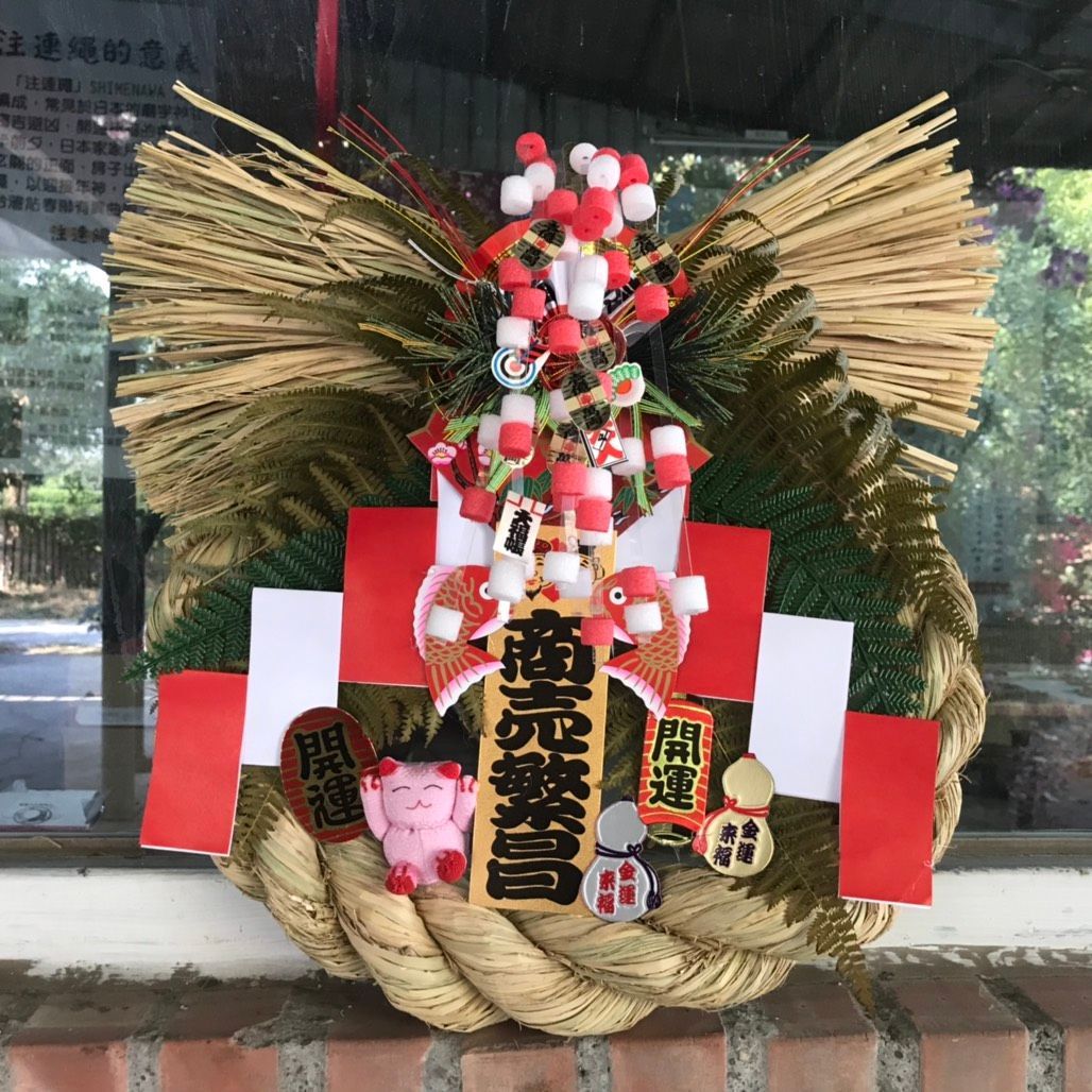 磚牆上掛著一個寫著中文的花環