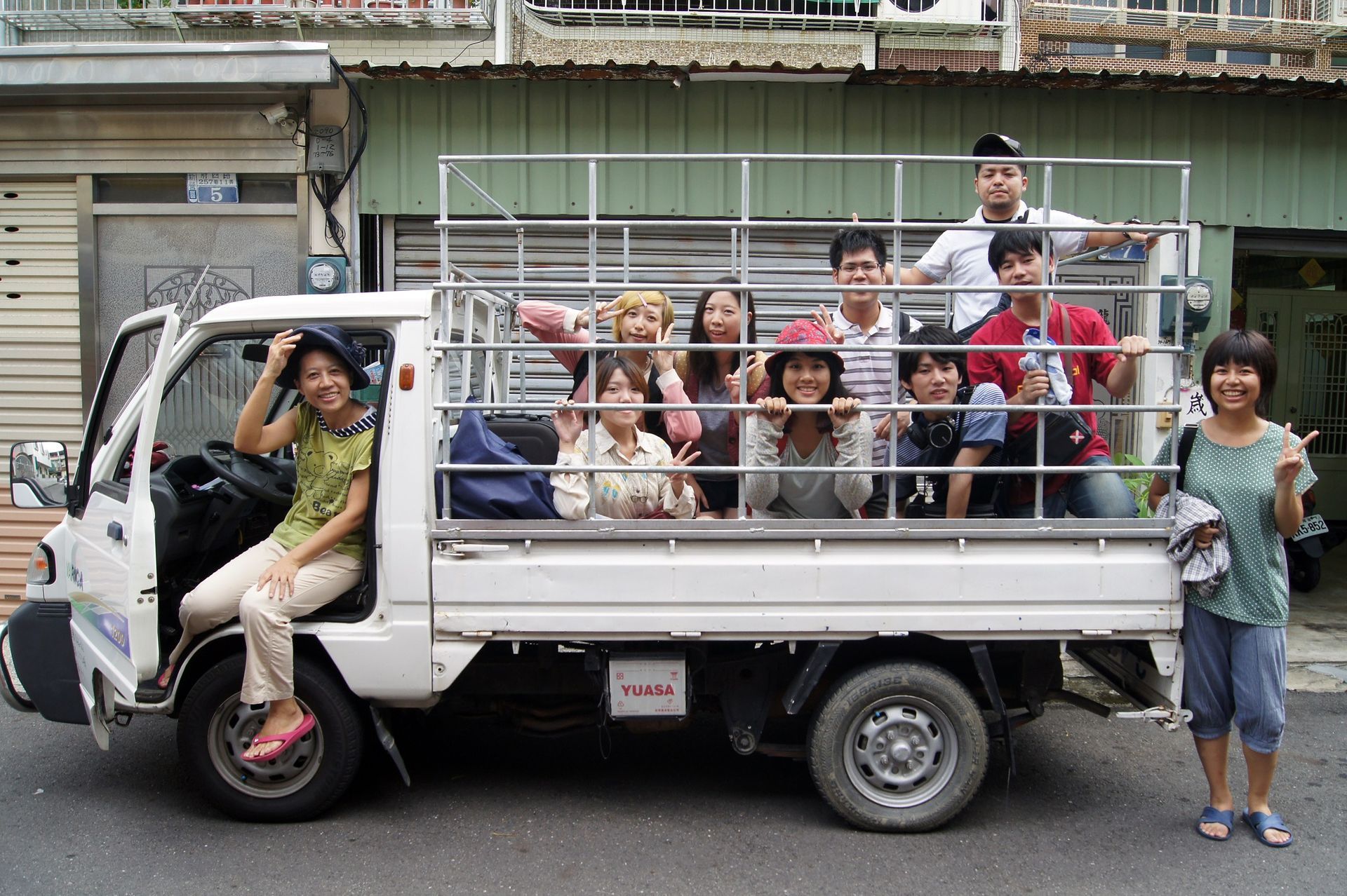 一群人在一輛卡車後面擺姿勢拍照。