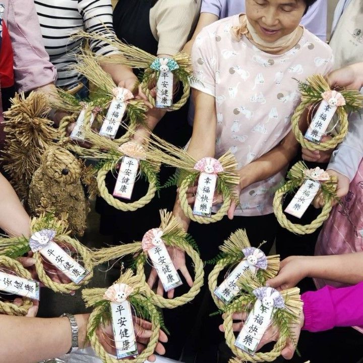 一群人手捧寫有中文的花圈