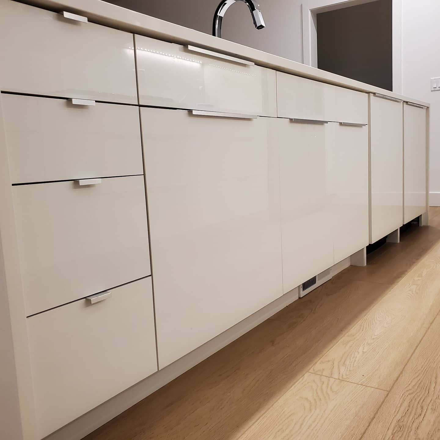 White modern kitchen cabinets with silver handles.