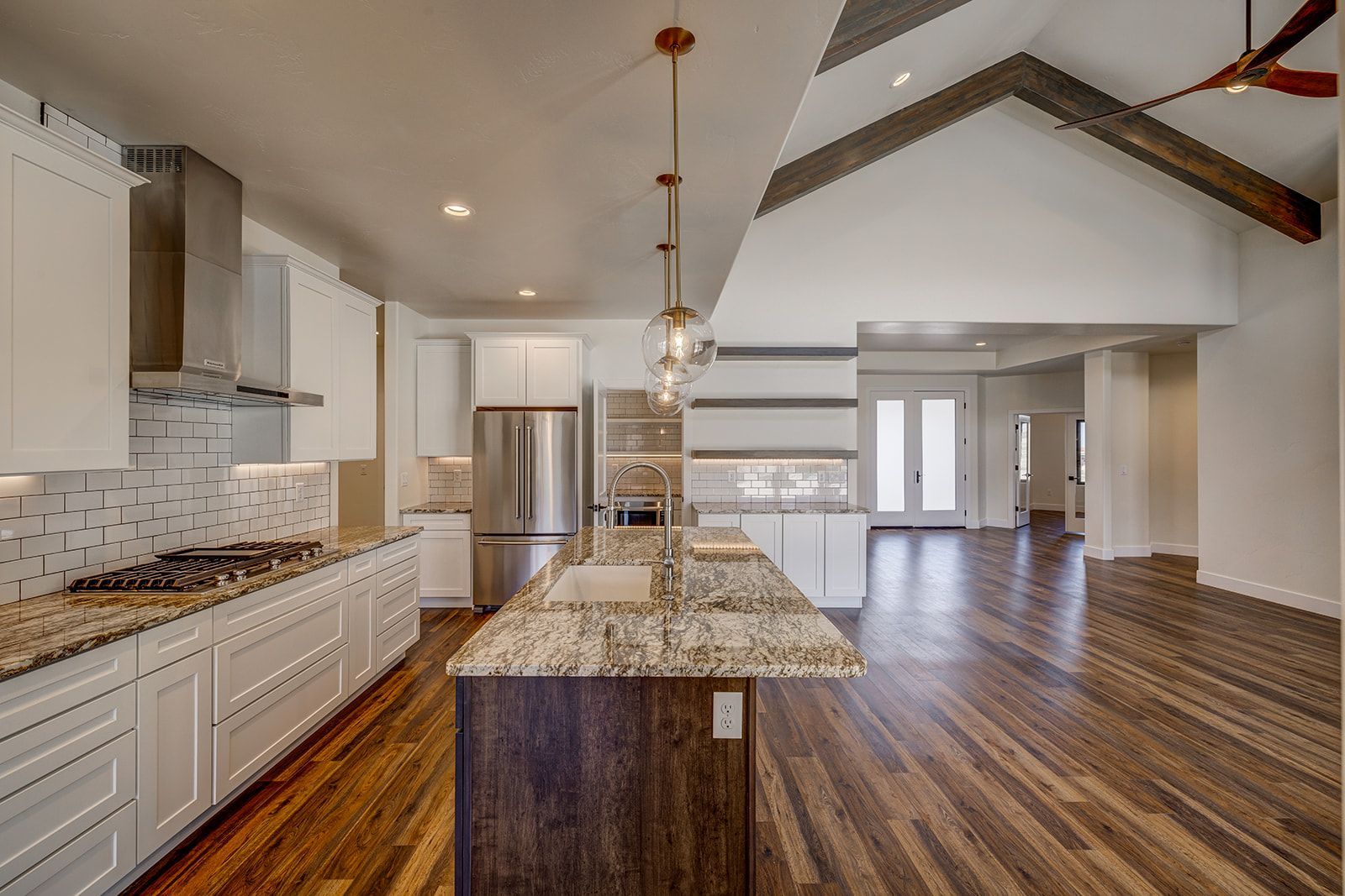 Modern kitchen with white cabinets, island, and wood floors.