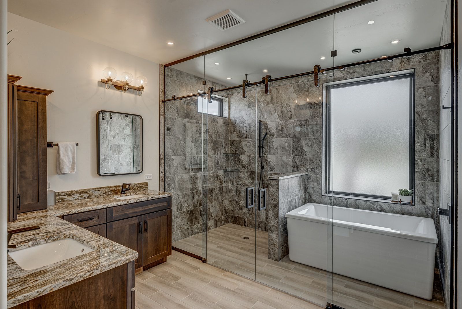 Modern bathroom with a glass shower, soaking tub, and dark wood cabinetry.