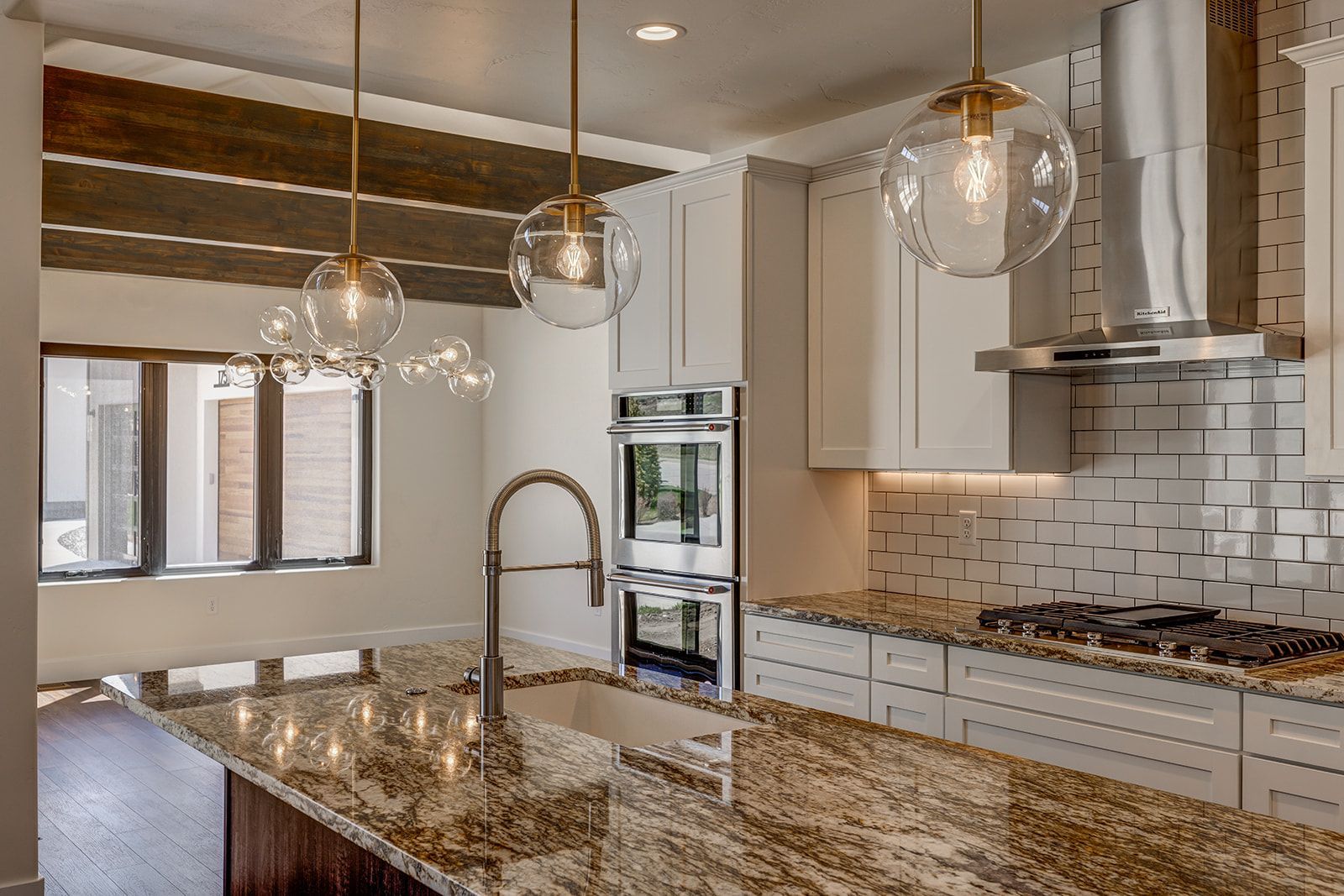 Kitchen with granite countertops, white cabinets, and globe pendant lights.
