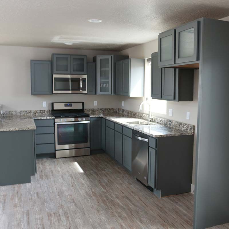 Gray kitchen with granite countertops, stainless steel appliances, and wood-look flooring.