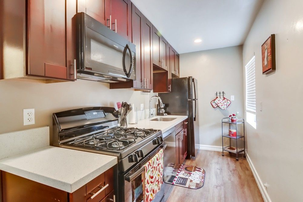 Woman with wavy brown hair, laughing with mouth open, wearing a green shirt against a white backdrop.