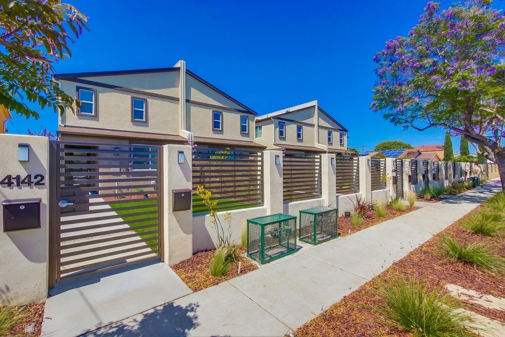 Woman with wavy brown hair, laughing with mouth open, wearing a green shirt against a white backdrop.