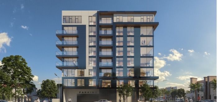 Blonde woman smiling, wearing a white shirt, against a light background.