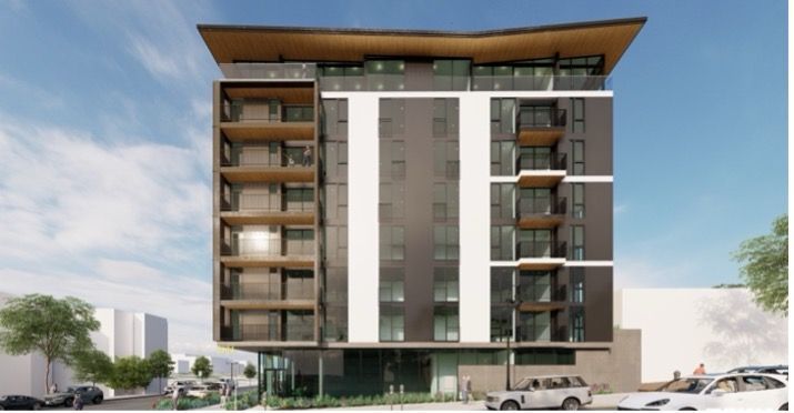 Man smiling, wearing a blue and white checkered shirt.