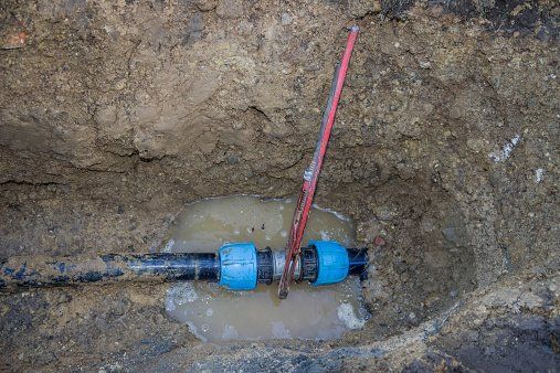 Broken pvc pipe in trench with wrench leaks water — Plumbing Services in San Rafael, CA