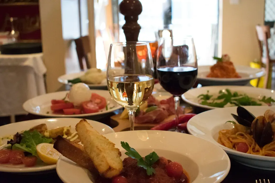 A table with plates of food and a glass of wine